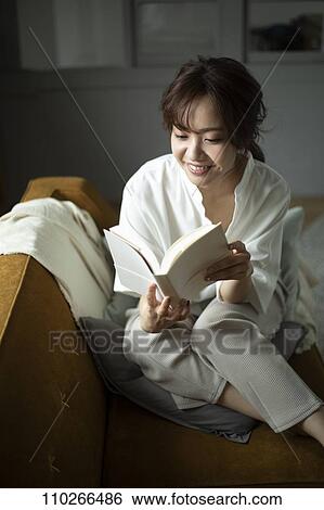 Stock Photograph - Young Japanese woman on the sofa. Fotosearch