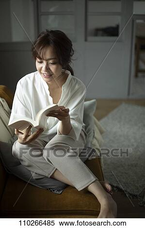Stock Photography - Young Japanese woman on the sofa. Fotosearch