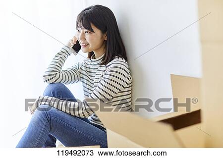 Stock Image - Young Japanese woman relocating. Fotosearch