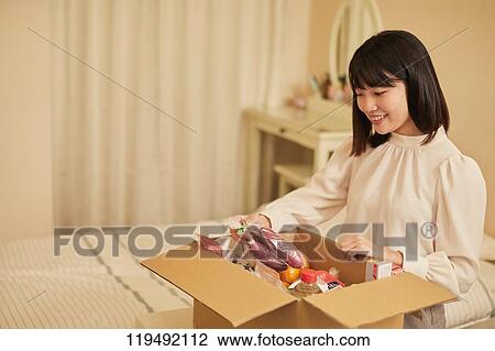 Stock Image - Young Japanese woman relocating. Fotosearch