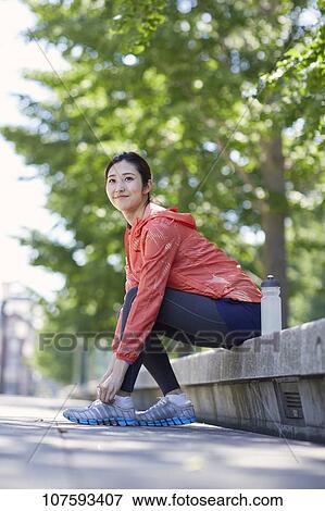 Stock Photo - Young Japanese woman running downtown Tokyo. Fotosearch
