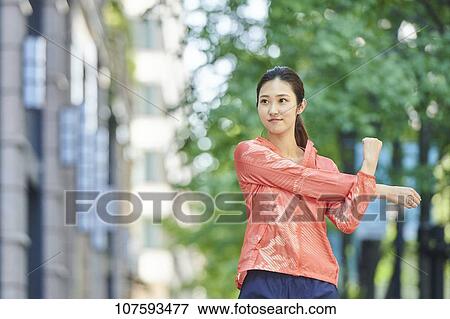 Stock Photo - Young Japanese woman running downtown Tokyo. Fotosearch