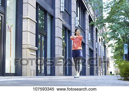 Stock Photography - Young Japanese woman running downtown Tokyo. Fotosearch