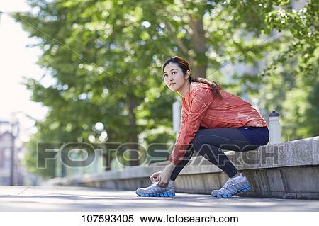 Stock Photography - Young Japanese woman running downtown Tokyo. Fotosearch