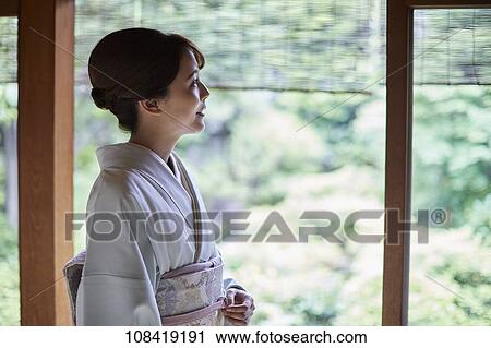 Stock Image - Young Japanese woman wearing traditional kimono. Fotosearch