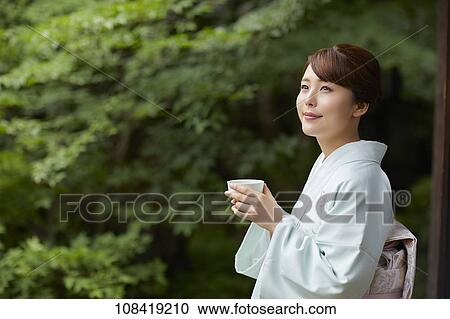 Stock Image - Young Japanese woman wearing traditional kimono. Fotosearch