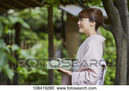 Stock Image - Young Japanese woman wearing traditional kimono. Fotosearch