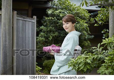 Stock Image - Young Japanese woman wearing traditional kimono. Fotosearch