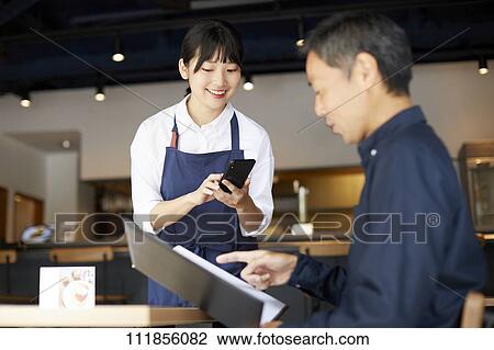 Young Japanese woman working at a restaurant View Large Photo Image Stock Image - Young Japanese woman working at a restaurant. Fotosearch