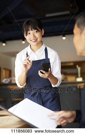 Young Japanese woman working at a restaurant View Large Photo Image Stock Image - Young Japanese woman working at a restaurant. Fotosearch