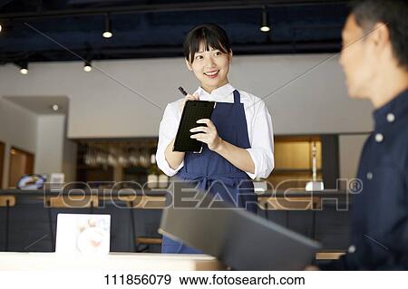 Stock Photo - Young Japanese woman working at a restaurant. Fotosearch