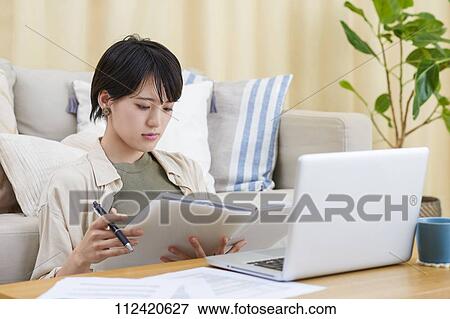 Young Japanese woman working at home View Large Photo Image Stock Photo - Young Japanese woman working at home. Fotosearch