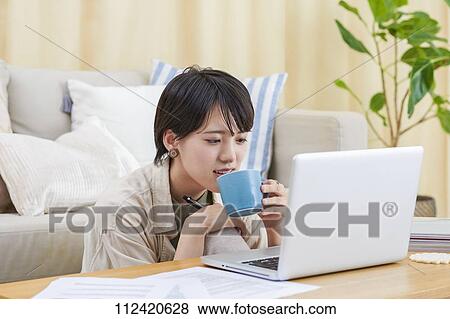 Young Japanese woman working at home View Large Photo Image Stock Photo - Young Japanese woman working at home. Fotosearch
