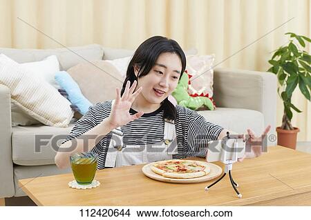 Picture - Young Japanese youtuber streaming at home. Fotosearch