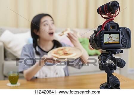 Stock Image - Young Japanese youtuber streaming at home. Fotosearch