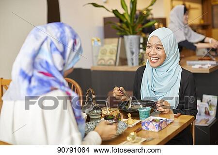Young South-east Asian women eating at restaurant View Large Photo Image Picture - Young South-east Asian women eating at restaurant. Fotosearch