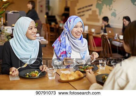 Young South-east Asian women eating at restaurant View Large Photo Image Stock Image - Young South-east Asian women eating at restaurant. Fotosearch