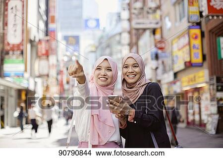 Picture - Young South-east Asian women enjoying sightseeing in Tokyo. Fotosearch