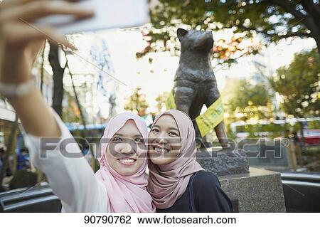 Stock Image - Young South-east Asian women enjoying sightseeing in Tokyo. Fotosearch