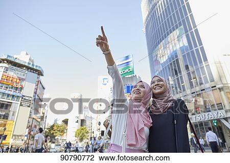 Stock Image - Young South-east Asian women enjoying sightseeing in Tokyo. Fotosearch