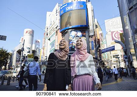 Stock Image - Young South-east Asian women enjoying sightseeing in Tokyo. Fotosearch