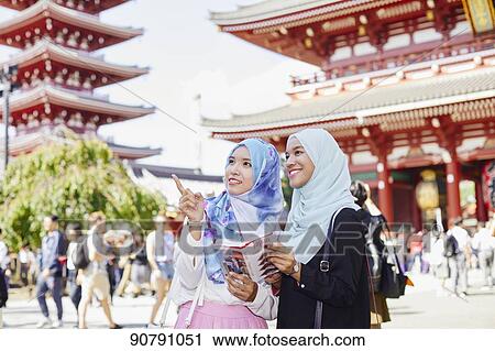 Stock Image - Young South-east Asian women enjoying sightseeing in Tokyo. Fotosearch