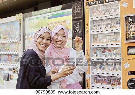 Stock Photo - Young South-east Asian women enjoying sightseeing in Tokyo. Fotosearch