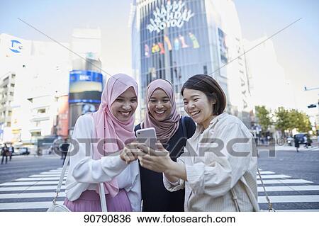 Stock Photograph - Young South-east Asian women enjoying sightseeing in Tokyo. Fotosearch