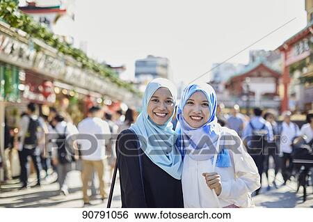 Stock Photograph - Young South-east Asian women enjoying sightseeing in Tokyo. Fotosearch