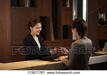 Young woman checking in at a hotel View Large Photo Image Stock Image - Young woman checking in at a hotel. Fotosearch