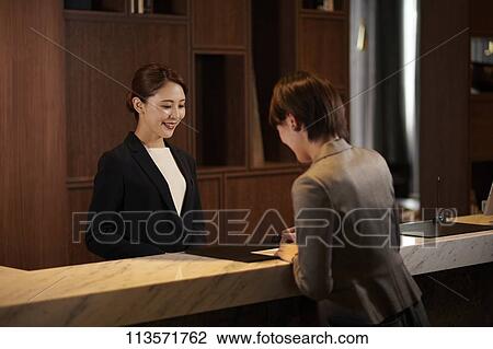 Young woman checking in at a hotel View Large Photo Image Stock Image - Young woman checking in at a hotel. Fotosearch