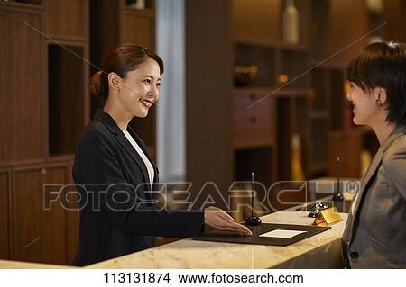 Young woman checking in at hotel View Large Photo Image Picture - Young woman checking in at hotel. Fotosearch