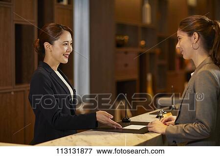 Young woman checking in at hotel View Large Photo Image Stock Photo - Young woman checking in at hotel. Fotosearch