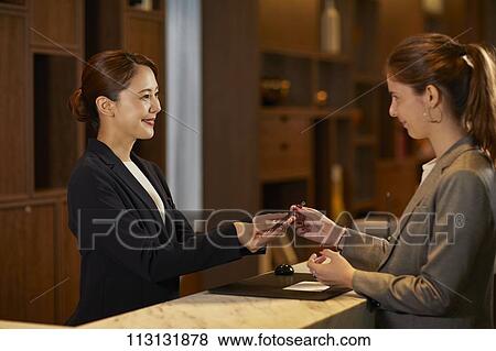 Young woman checking in at hotel View Large Photo Image Stock Photo - Young woman checking in at hotel. Fotosearch