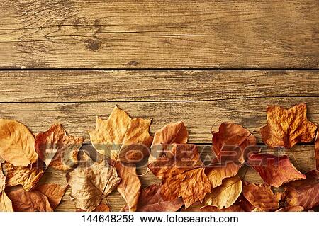 Autumn leaves on wooden table View Large Photo Image Stock Photo - Autumn leaves on wooden table. Fotosearch