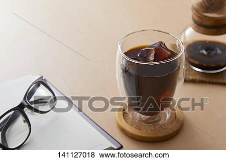 Stock Photo - Glass Of Coffee On The Desk. Fotosearch