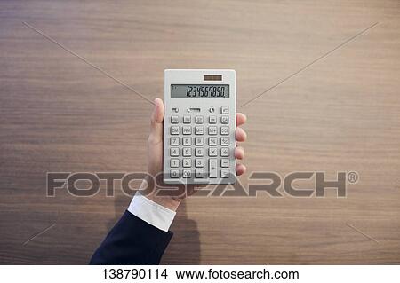 Hand Holding An Electronic Calculator View Large Photo Image Picture - Hand Holding An Electronic Calculator. Fotosearch
