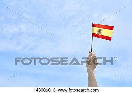 Hand holding flag against blue sky View Large Photo Image Stock Image - Hand holding flag against blue sky. Fotosearch