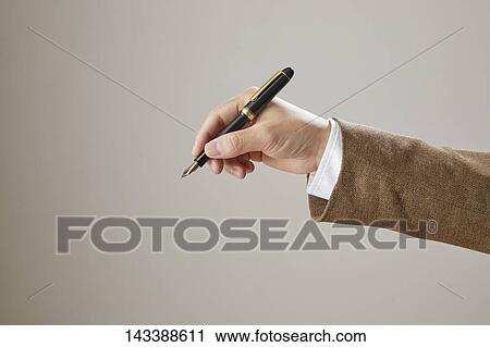 Stock Image - Hand holding pen. Fotosearch