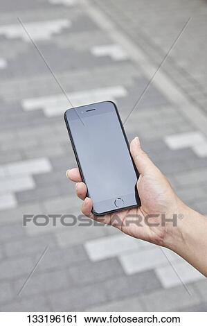 Stock Image - Hand Holding Smartphone. Fotosearch