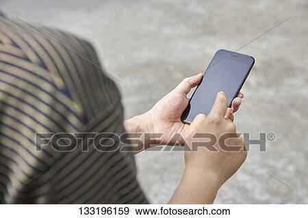 Stock Photo - Hand Holding Smartphone. Fotosearch