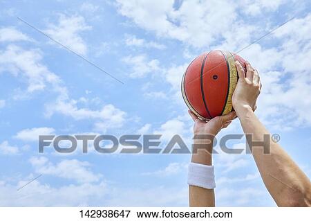 Hands holding basketball against blue sky View Large Photo Image Stock Photo - Hands holding basketball against blue sky. Fotosearch