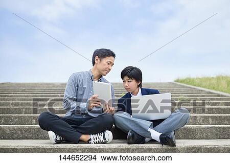Picture - Happy Japanese father and son outdoors. Fotosearch