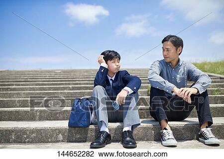 Stock Image - Happy Japanese father and son outdoors. Fotosearch