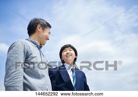 Stock Image - Happy Japanese father and son outdoors. Fotosearch