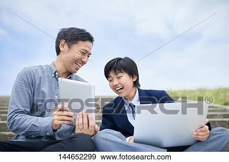 Stock Photo - Happy Japanese father and son outdoors. Fotosearch