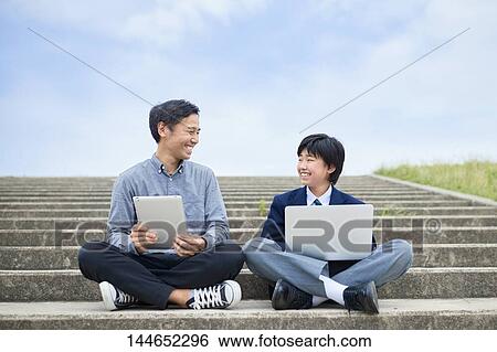 Stock Photograph - Happy Japanese father and son outdoors. Fotosearch