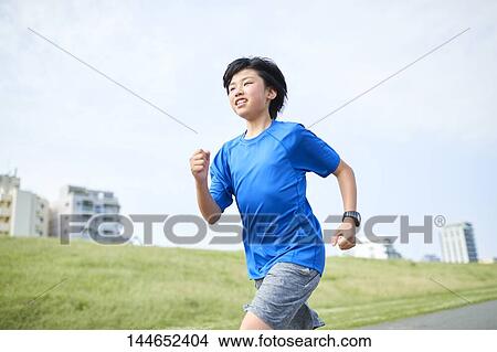 Picture - Happy Japanese teenager enjoying himself outdoors. Fotosearch