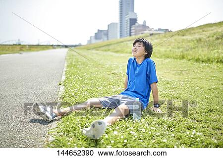Stock Image - Happy Japanese teenager enjoying himself outdoors. Fotosearch