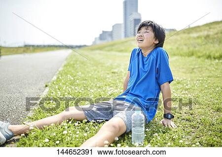 Stock Image - Happy Japanese teenager enjoying himself outdoors. Fotosearch